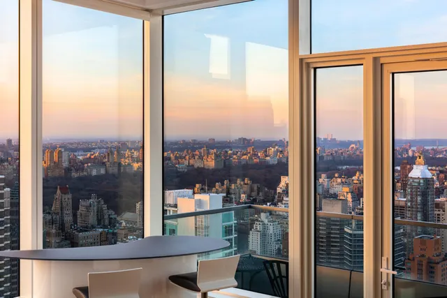 a living room with furniture kitchen view and large windows