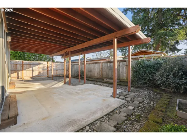 a backyard of a house with barbeque oven table and chairs