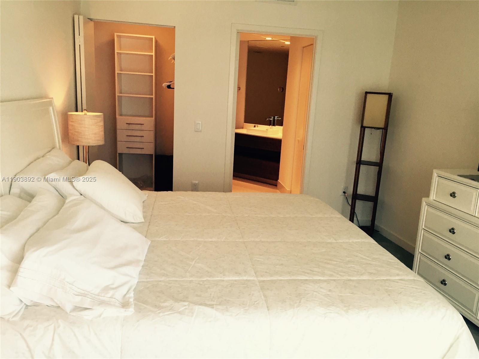 1100 South Miami Avenue, Unit 710 Miami, FL 33130 - Photo 14 of 20 a bedroom with a bed and dresser with mirror