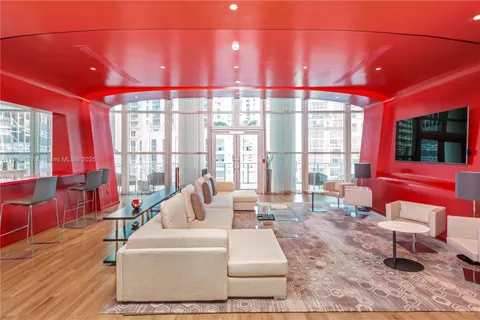 a living room with furniture a window and a flat screen tv