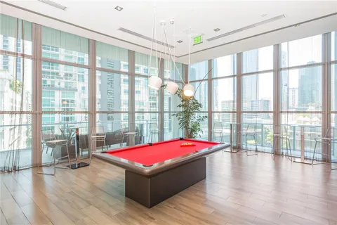a room with pool table and windows