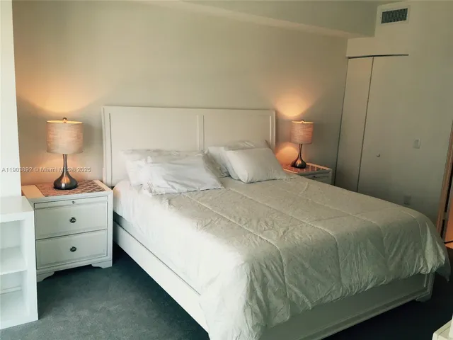 a bedroom with a bed and a lamp