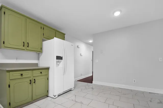 a kitchen with a refrigerator and cabinets