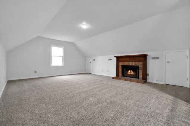 an empty room with a fireplace and window