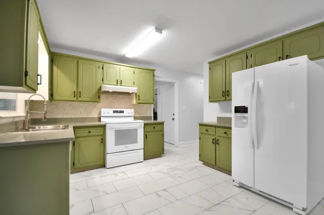 a kitchen with a refrigerator sink and stove