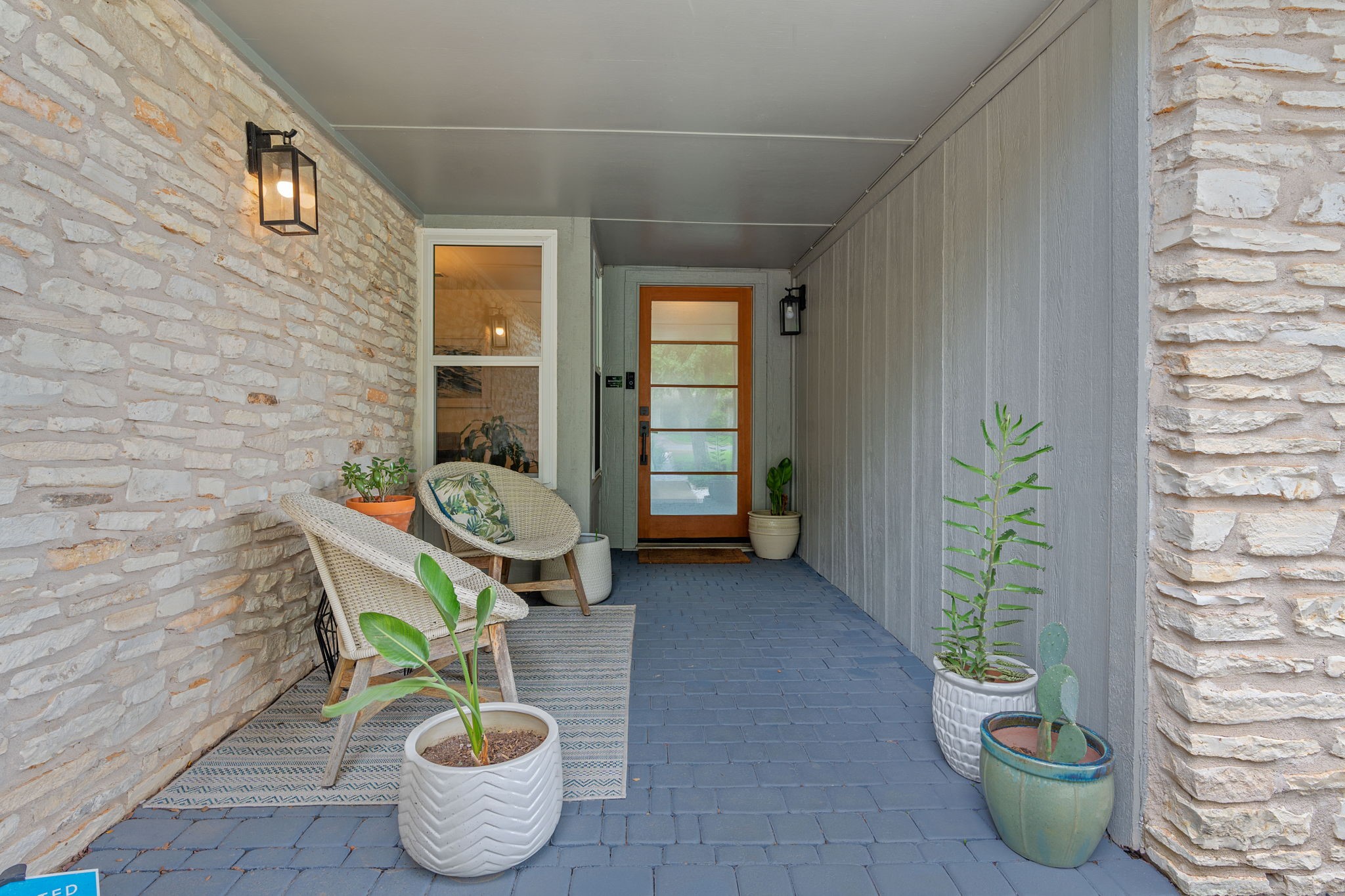 a balcony with chairs and a potted plant