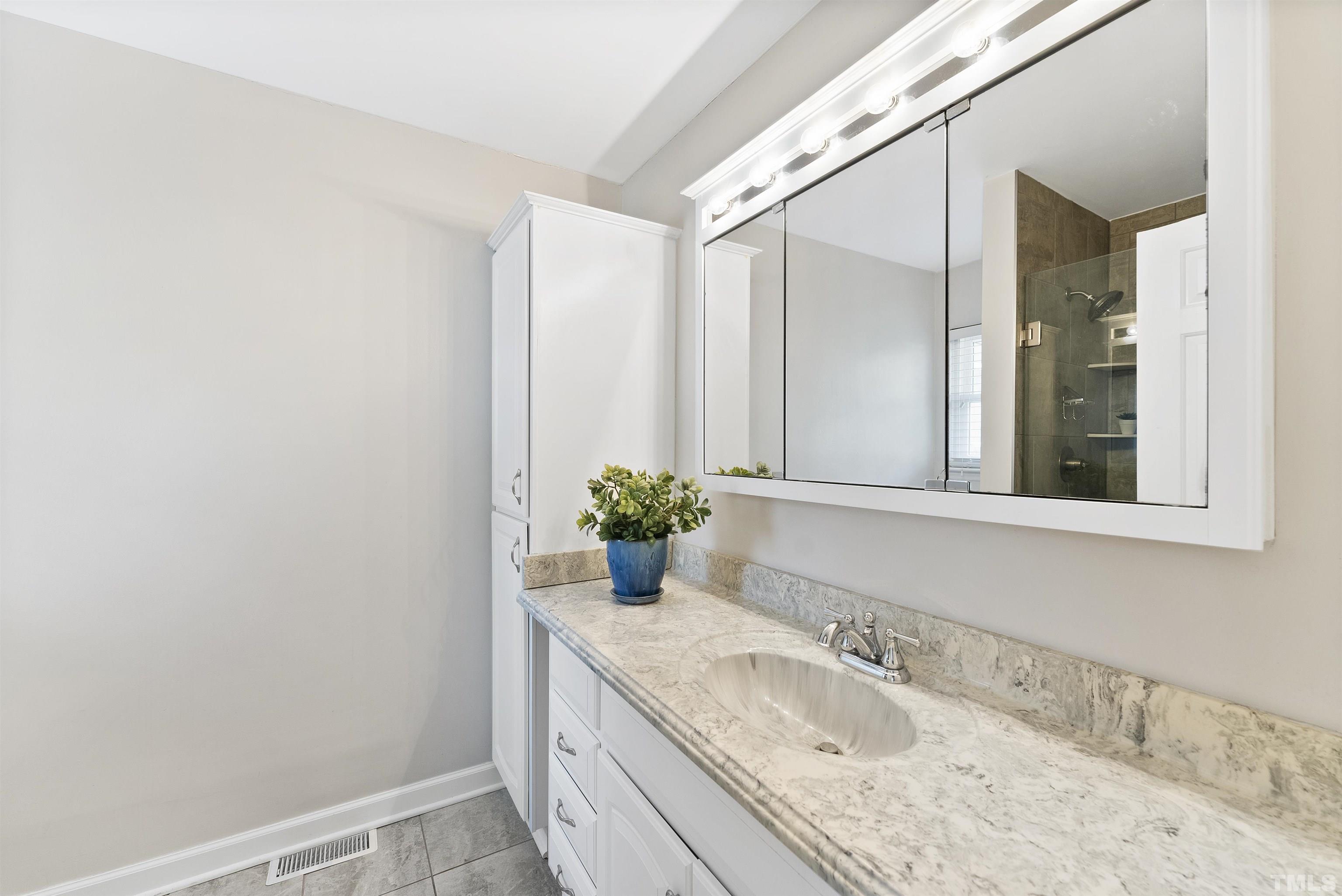 5413 Old Towne Road Raleigh, NC 27612 - Photo 26 of 34 a bathroom with a granite countertop sink a mirror and a shower
