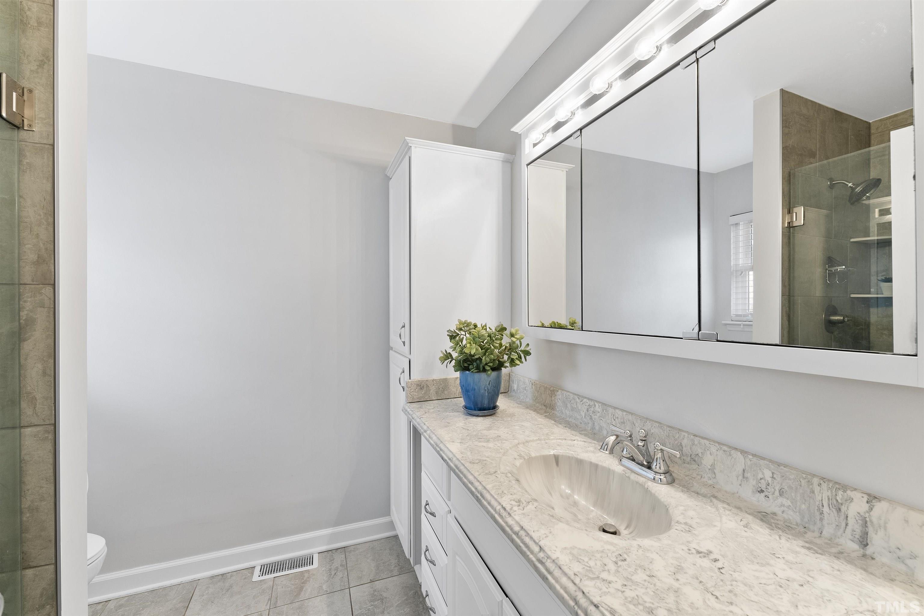 5413 Old Towne Road Raleigh, NC 27612 - Photo 27 of 34 a bathroom with a granite countertop sink and a mirror