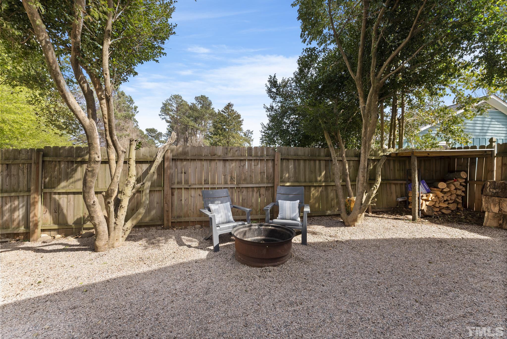 5413 Old Towne Road Raleigh, NC 27612 - Photo 4 of 34 a view of a backyard with a sitting area and covered with tall trees