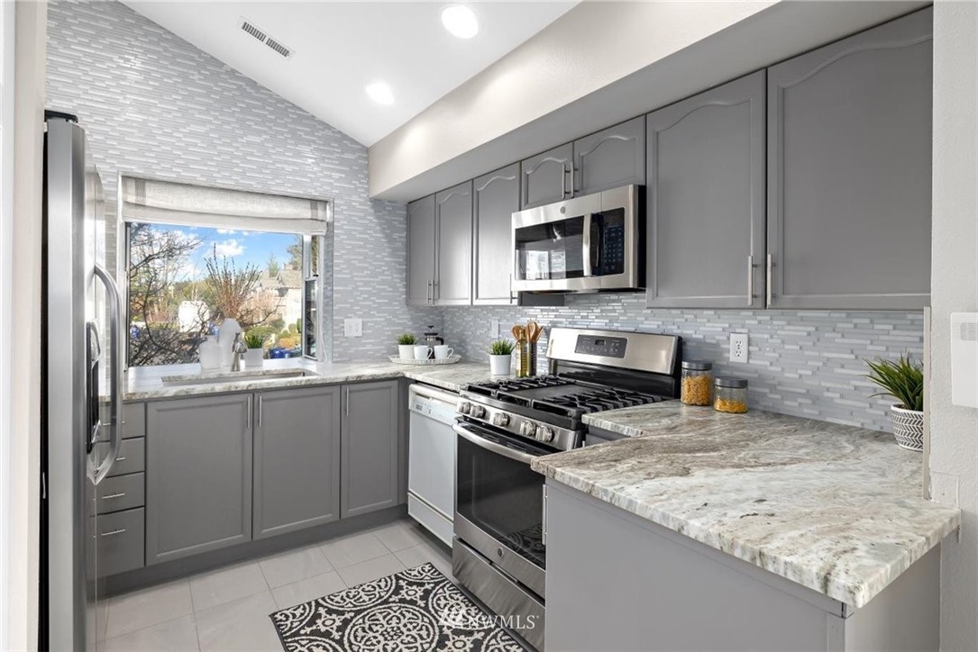 22709 4th Avenue West, Unit 105 Bothell, WA 98021 - Photo 18 of 32 a kitchen with stainless steel appliances granite countertop a stove a sink and a microwave