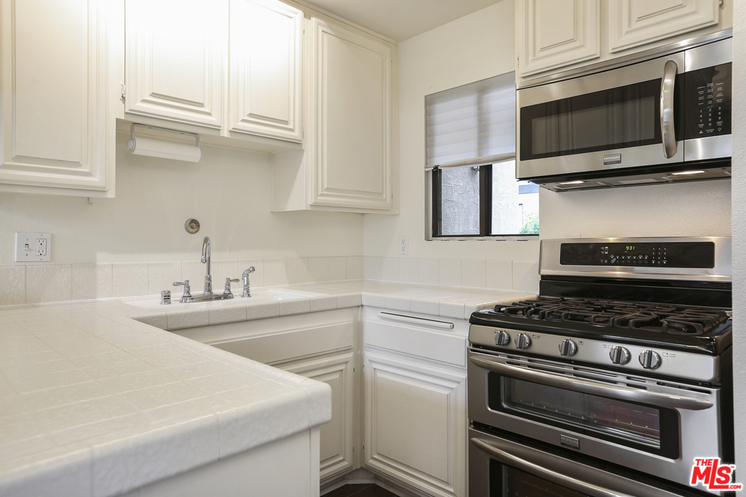 8110 Manitoba Street, Unit 105 Playa del Rey, CA 90293 - Photo 11 of 28 a kitchen with cabinets stainless steel appliances and a sink