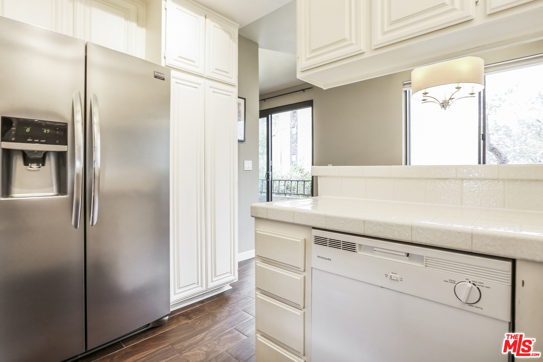 8110 Manitoba Street, Unit 105 Playa del Rey, CA 90293 - Photo 12 of 28 a kitchen with white cabinets and refrigerator