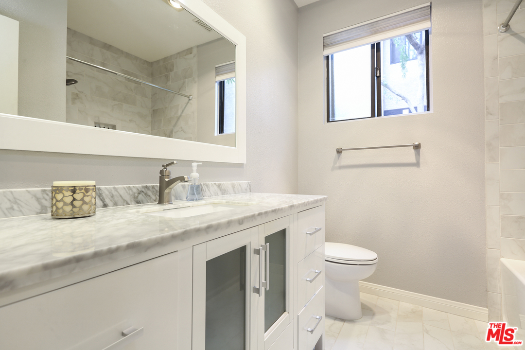 8110 Manitoba Street, Unit 105 Playa del Rey, CA 90293 - Photo 17 of 28 a bathroom with a granite countertop sink a toilet and a mirror