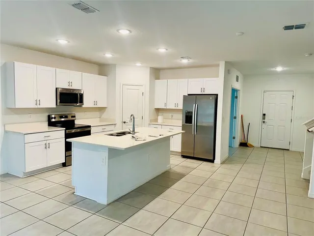 a kitchen with a sink a counter top space stainless steel appliances and cabinets