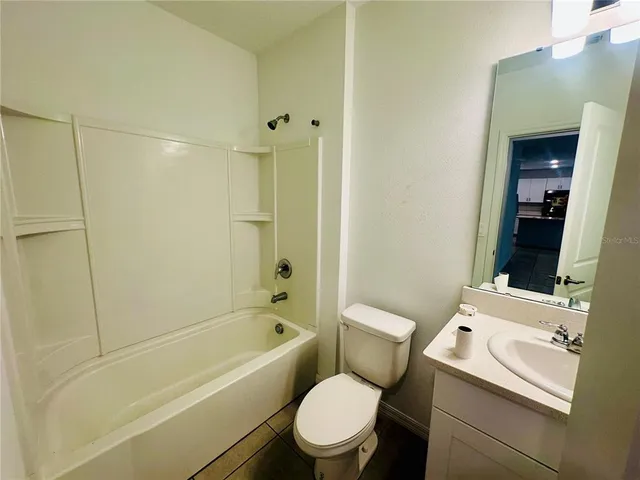 a white toilet sitting next to a bath tub