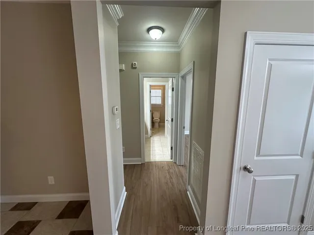 an empty room with wooden floor chandelier fan and windows