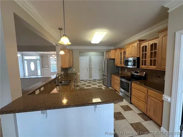 a kitchen with a checkered floor and a black refrigerator