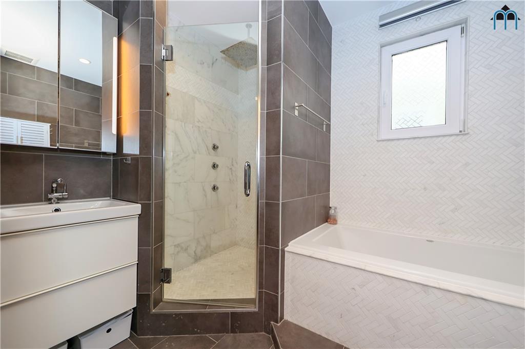 2 Brighton 4th Road Brooklyn, NY 11235 - Photo 18 of 31 a bathroom with a bathtub and a sink