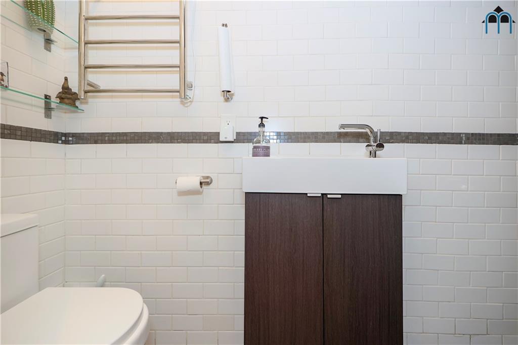 2 Brighton 4th Road Brooklyn, NY 11235 - Photo 7 of 31 a bathroom with a sink and mirror
