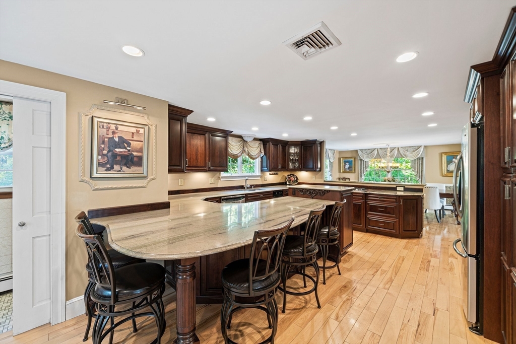 5 Lehan Street Canton, MA 02021 - Photo 12 of 27 a kitchen with stainless steel appliances granite countertop table chairs and wooden floor
