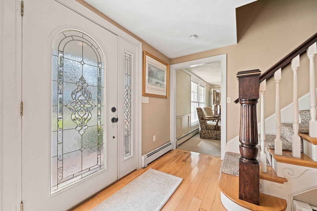 5 Lehan Street Canton, MA 02021 - Photo 3 of 27 a view of a hallway with wooden floor and a living room