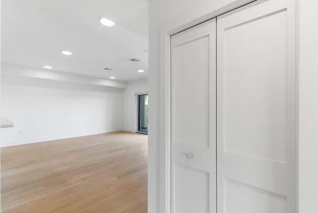 a view of an empty room with closet and a window