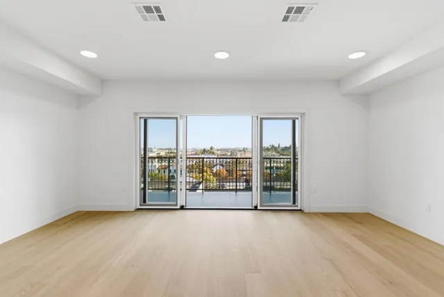 a view of an empty room with glass door and chandelier