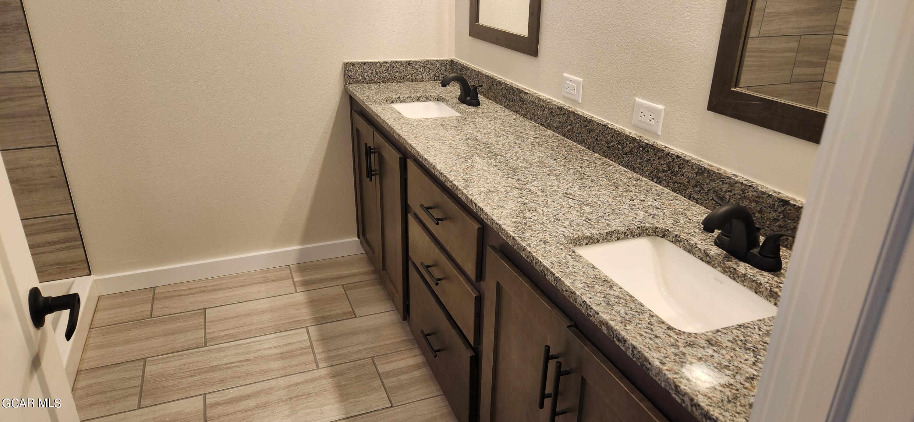 a bathroom with a granite countertop sink and washing machine