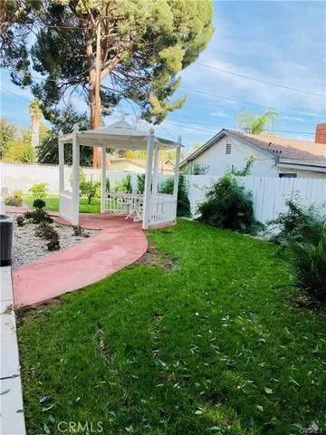 a view of a house with garden and a tree