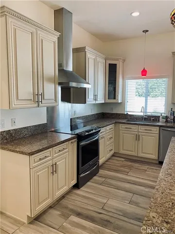 a kitchen with stainless steel appliances granite countertop a sink a stove and a refrigerator