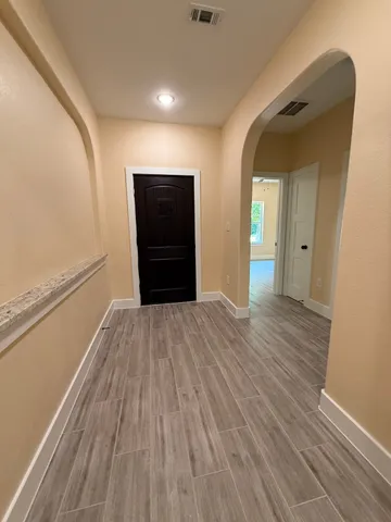 a view of a hallway with wooden floor