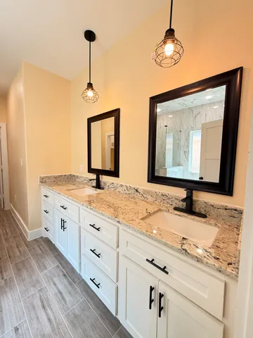 a bathroom with double vanity sink and a mirror