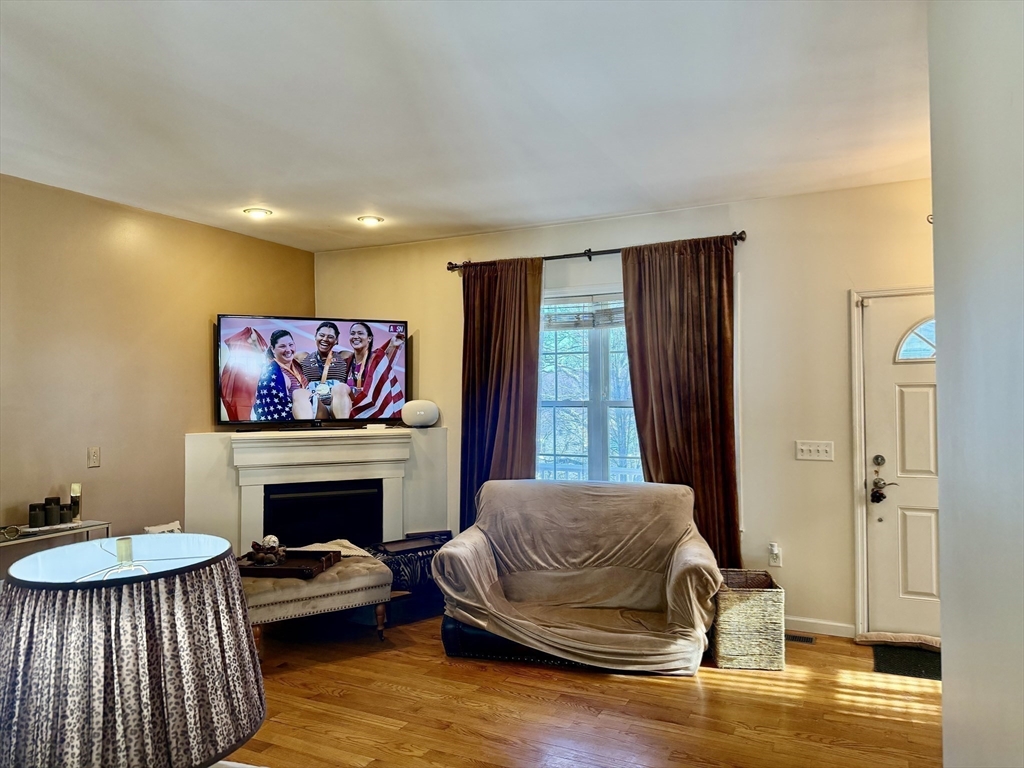 10 Milton Ridge Road, Unit 10 Lynn, MA 01902 - Photo 22 of 33 a living room with furniture a fireplace and a flat screen tv