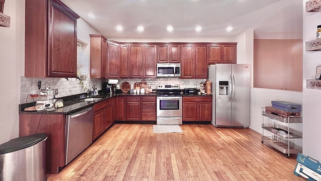 10 Milton Ridge Road, Unit 10 Lynn, MA 01902 - Photo 4 of 33 a kitchen with stainless steel appliances granite countertop a refrigerator a sink dishwasher a stove and a refrigerator with wooden floor