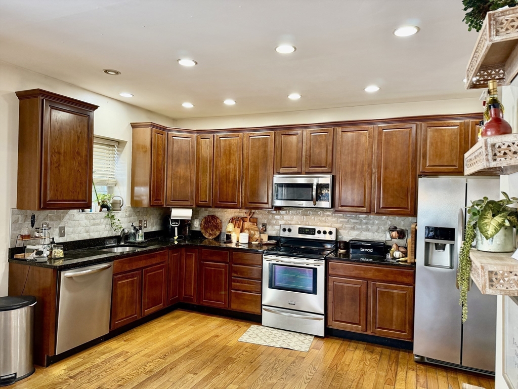 10 Milton Ridge Road, Unit 10 Lynn, MA 01902 - Photo 7 of 33 a kitchen with stainless steel appliances granite countertop a stove top oven a sink dishwasher a refrigerator and cabinets with wooden floor