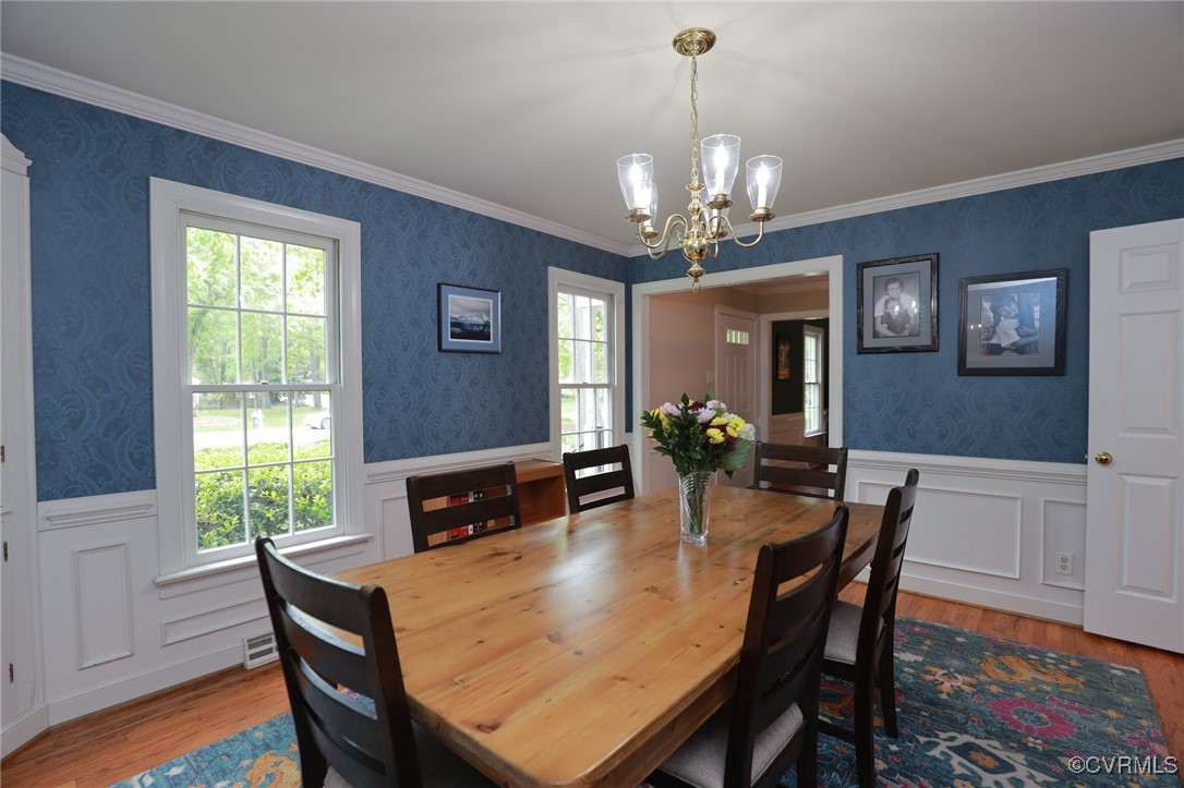 12830 Foxstone Road Midlothian, VA 23113 - Photo 13 of 42 a dining room with wooden floor a chandelier a wooden table and chairs
