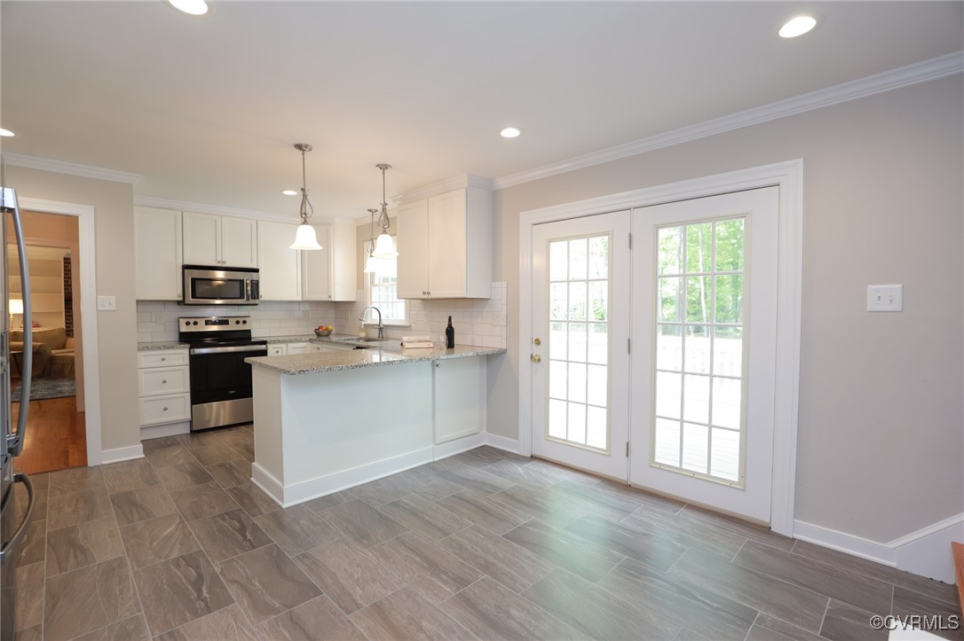 12830 Foxstone Road Midlothian, VA 23113 - Photo 9 of 42 a large kitchen with kitchen island a large counter top space a sink stainless steel appliances and cabinets