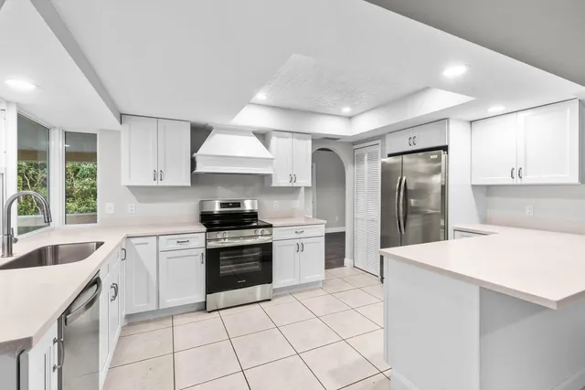 a kitchen with granite countertop a sink stove and refrigerator
