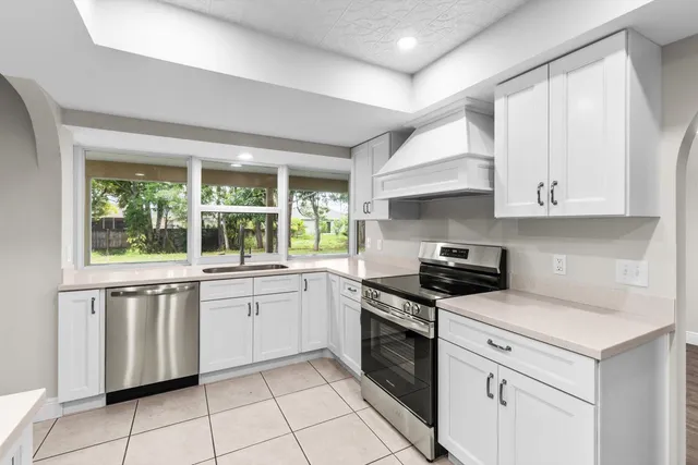 a kitchen with white cabinets appliances and a sink