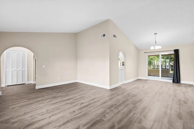 an empty room with wooden floor and mirror