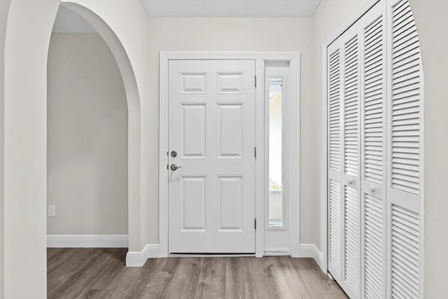 an empty room with wooden floor and closet area
