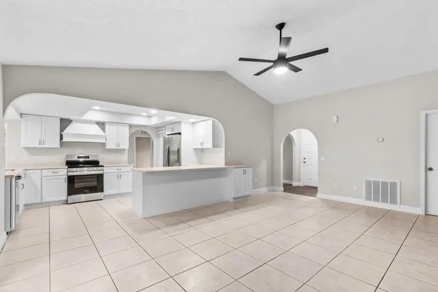 a large white kitchen with cabinets