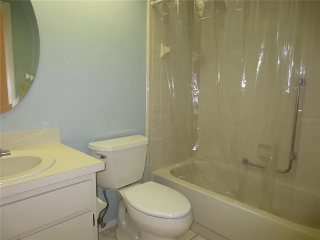 a white toilet sitting next to a bath tub