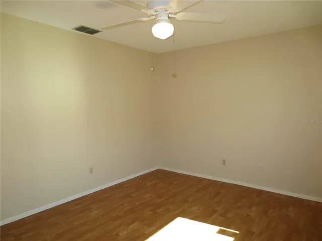 a view of a room with wooden floor and fan
