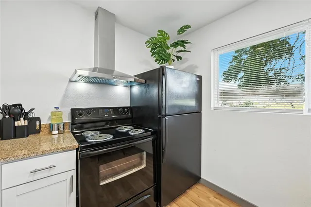 a kitchen with granite countertop a stove and a refrigerator