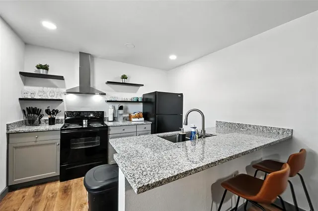 a kitchen with stainless steel appliances granite countertop a sink a stove and refrigerator