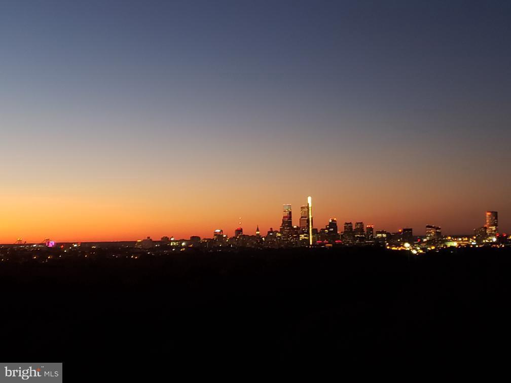 3900 West Ford Road, Unit 14K Philadelphia, PA 19131 - Photo 16 of 53 City skyline at dusk, vibrant hues blend.