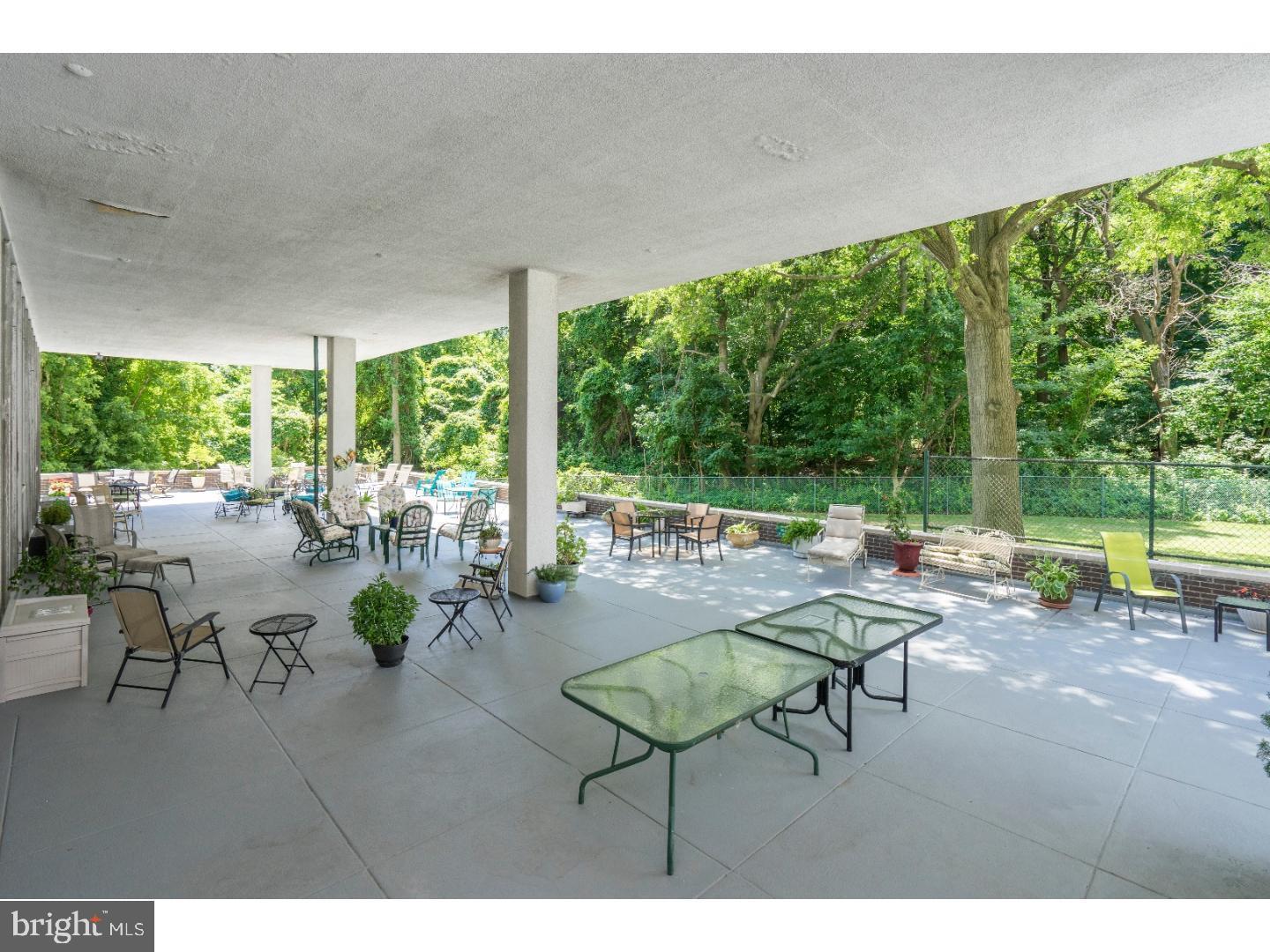 3900 West Ford Road, Unit 14K Philadelphia, PA 19131 - Photo 39 of 53 Spacious patio embraced by lush greenery.