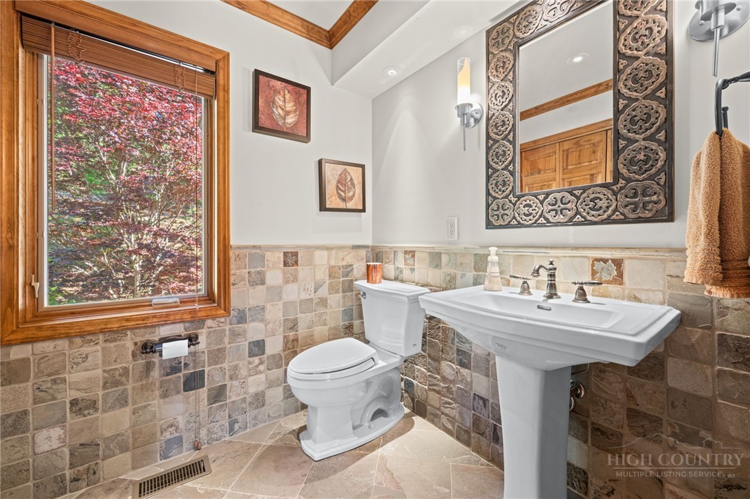 331 Alpine Road Blowing Rock, NC 28605 - Photo 22 of 50 a bathroom with a sink a toilet and a mirror