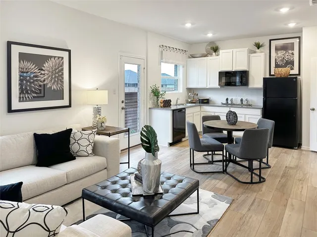 a living room with furniture a dining table and kitchen view